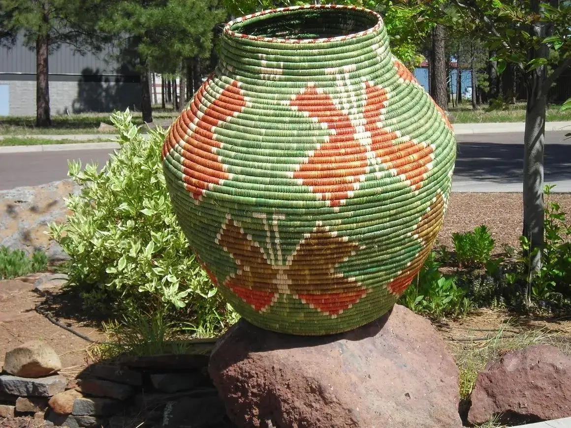 Large woven basket with geometric patterns outdoors.