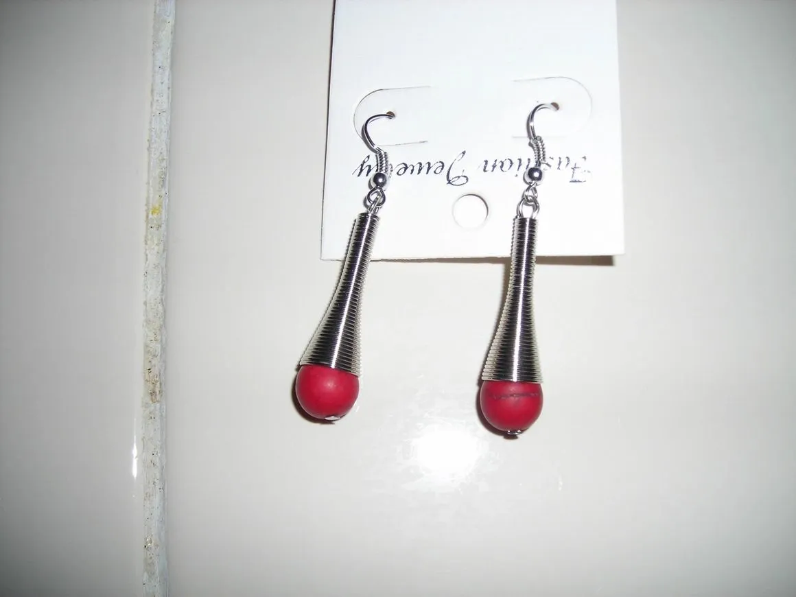 Red and silver teardrop earrings on card.