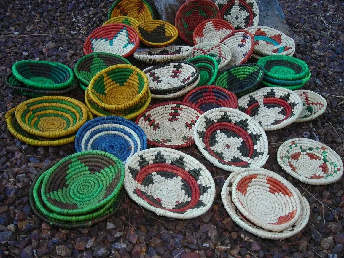 Colorful woven baskets on rocky ground.