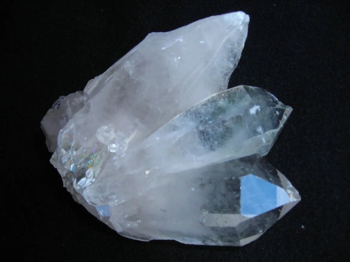 Clear quartz crystal cluster on black background.