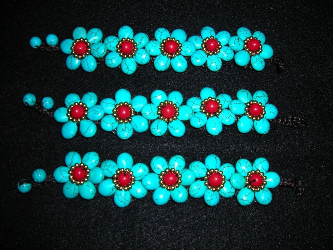 Turquoise flower bracelets with red centers.