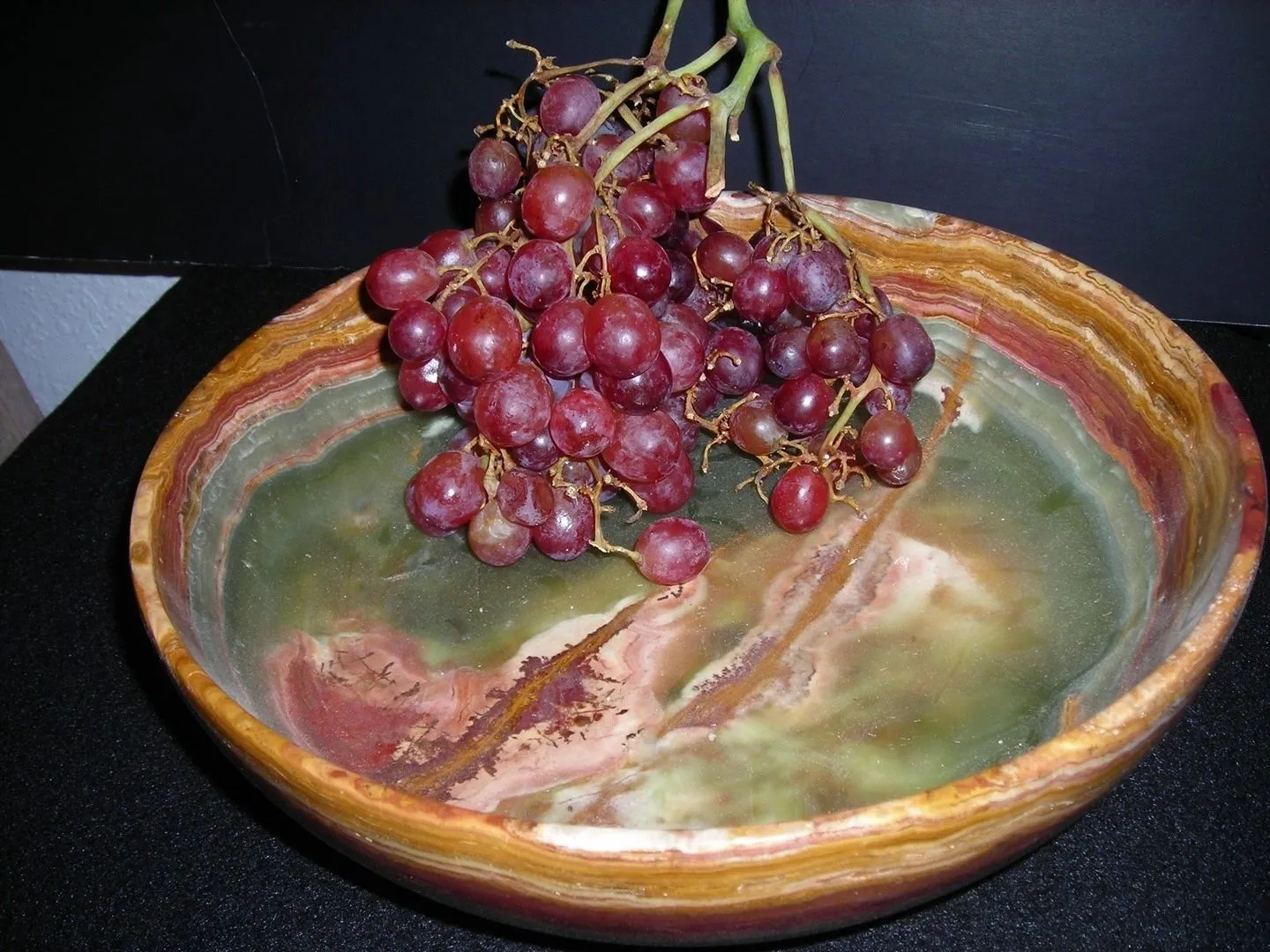Grapes in a colorful ceramic bowl.