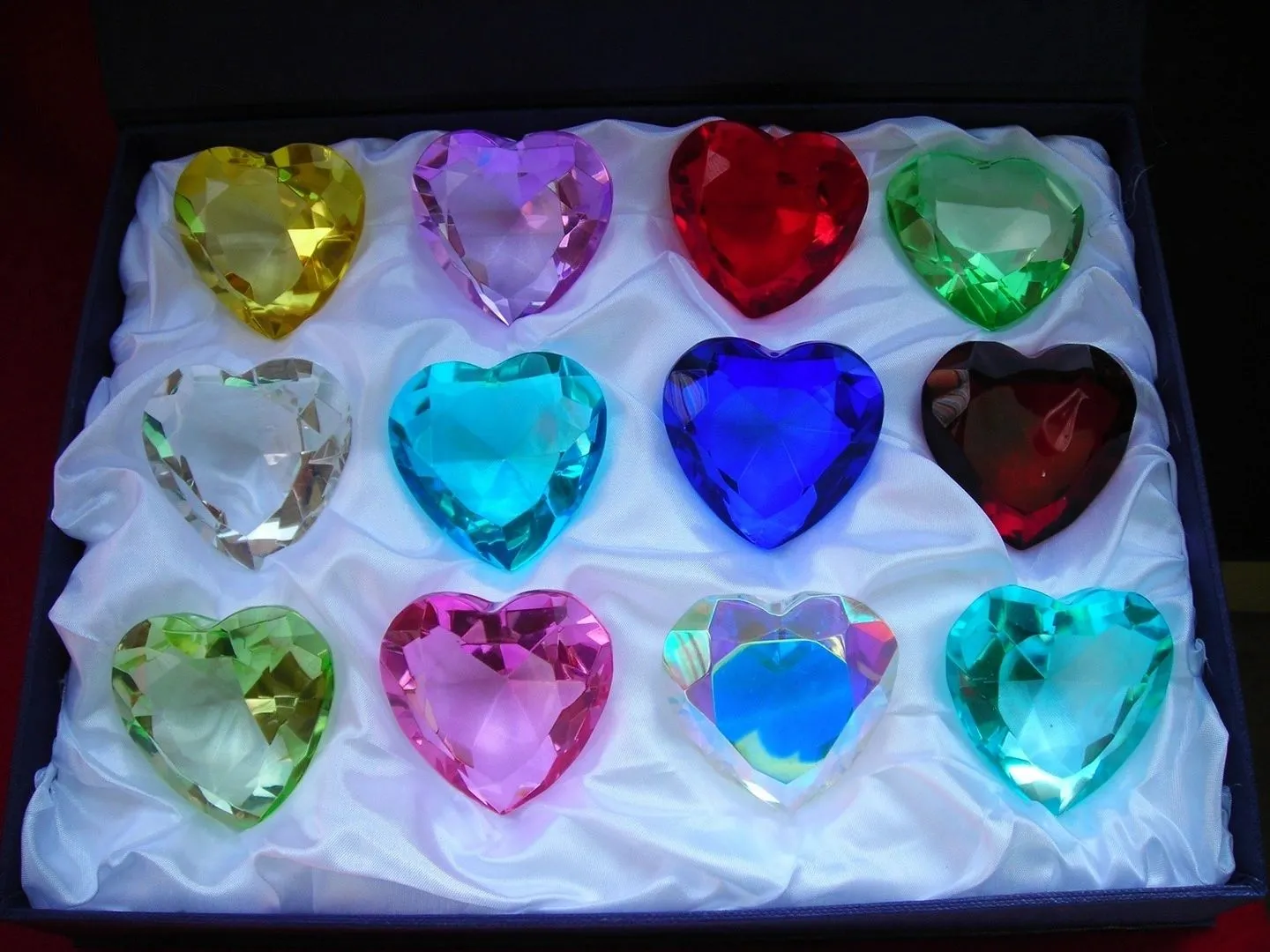 Colorful heart-shaped crystals on white fabric.